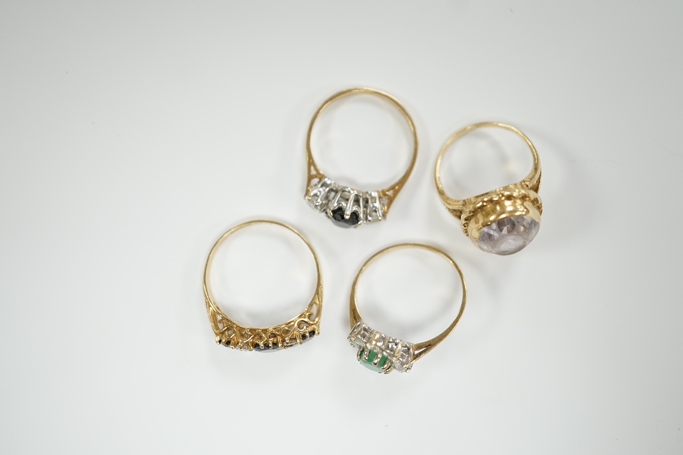 Four assorted modern 9ct gold and gem set dress rings, including sapphire and simulated diamond, gross weight 9.9 grams.